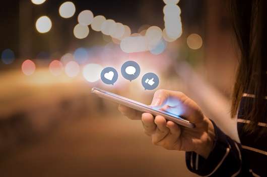 A women is using her phone to see her social media reach